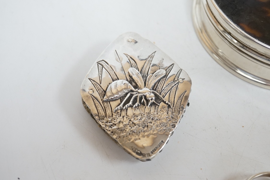 A George V silver and tortoiseshell pique mounted circular trinket box, Collett & Anderson, London, 1922, diameter 77mm, together with a pair of 18th century silver sugar nips and a sterling mounted pin cushion, decorate